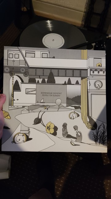 A black white and yellow drawing vinyl cover of a train going over a park