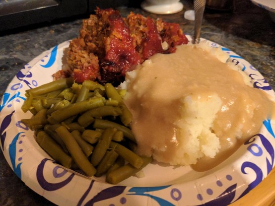 Beanloaf, mashed potatoes and gravy, green beans. Paper plate.