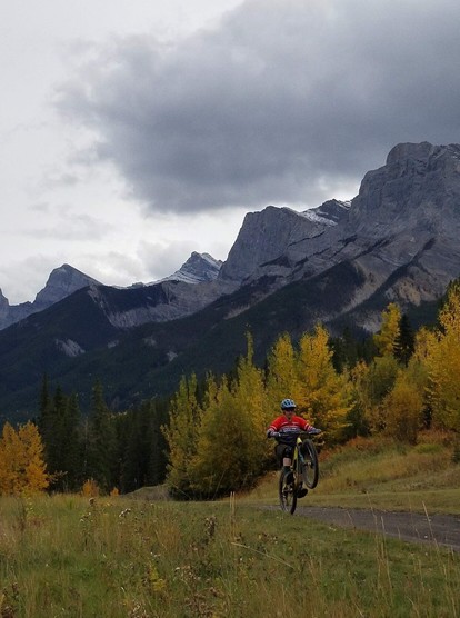Doing a wheelie while mountain biking in the Canadian Rockies, Canmore, Alberta in fall.