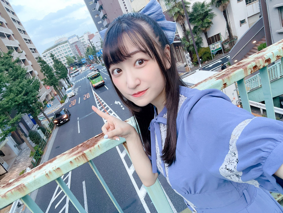 Kanon pointing to the street standing on the bridge.