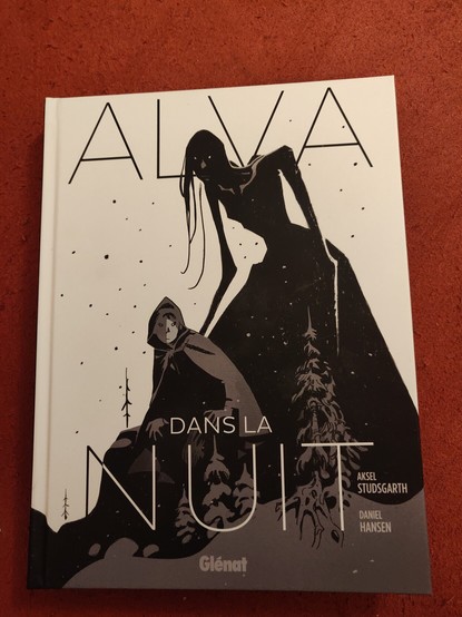 Couverture de "Alva - Dans la nuit" de Aksel Studsgarth et Daniel Hansen, édité chez Glénat.

La couverture est en noire et blanc et représente un jeune personnage avec une cape dans la neige surplombé par l'ombre d'une femme décharnée avec de longs et maigres bras.