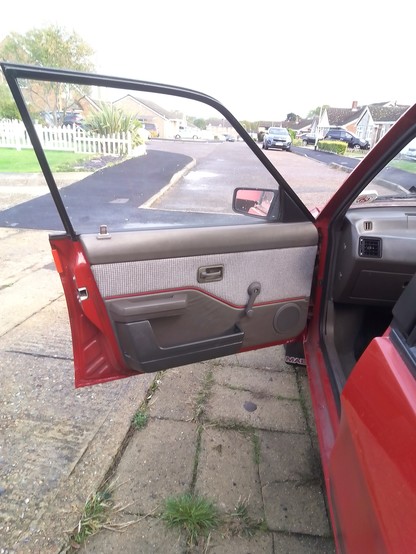 A 1988 Austin Maestro with the front door open showing the Special trim with such luxuries as door bins, tweed and vinyl two tone trim, and a smart claret piping line.