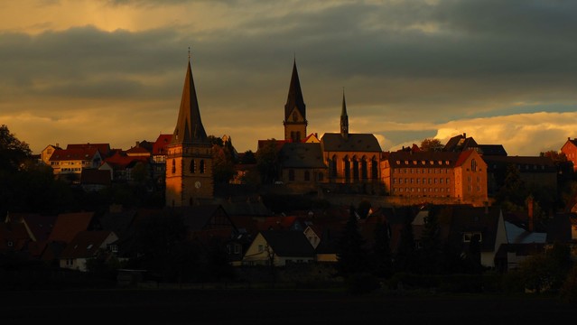 "skyline " von Warburg in goldenem Herbstlicht. Es sind drei Kirchen und Fachwerkhäuser zu sehen