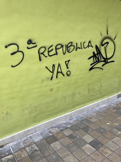 Black graffiti on a green wall:

3Â° RepÃºblica Ya!

3rd Republic Now!