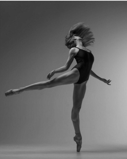 Ballerina in a leotard, with loose hair, spins en Pointe.