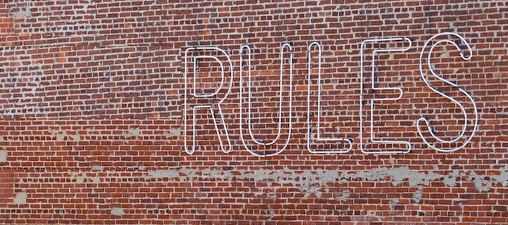 Brick wall with the word rule on it.