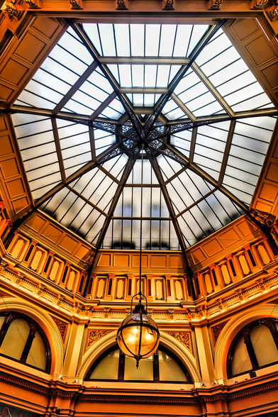An octagonal ceiling window at the top with a lamp hanging down from the middle in Collins arcade in Melbourne CBD