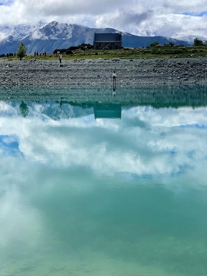 A small church reflects in the turquoise waters of Tekapo River