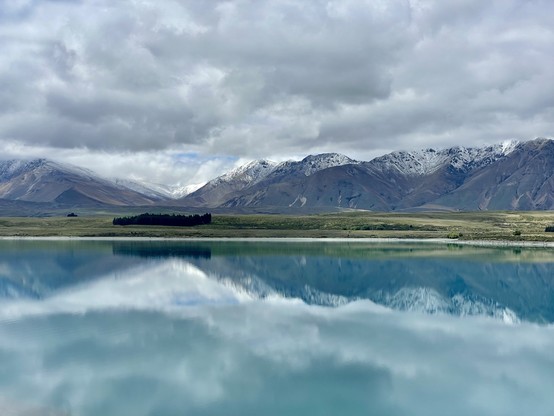 Two Thumbs Range with a dusting of snow reflected in Lake Tekapo; overcast above