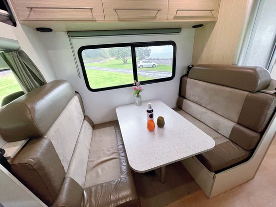 Dinette area with seating for 4–6, table under window & over head lockers