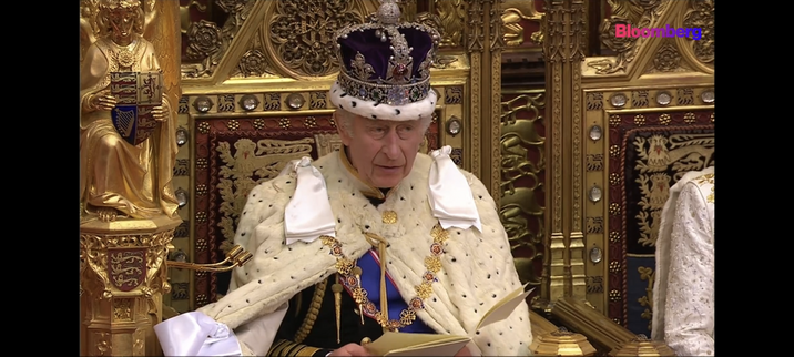 His Royal Highness King Charles the 2nd sits on his ornate throne with a crown and cape that make him look like a comical super villain or the most out of touch human alive. Either way it's both sad and disgusting.