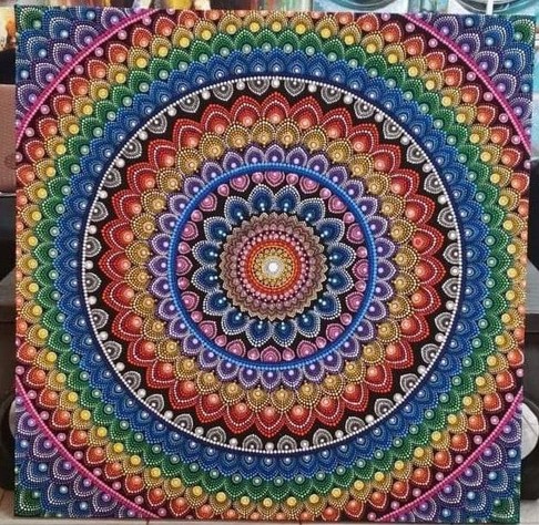 a photo of a large mandala painting done in a prism of colors, done with many tiny dots