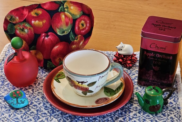 A tea tableau with an apple theme and a cat napping, and apple black tea.