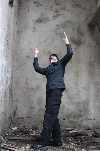 Gif animaation of a black dressed male representing human doing a celebratory ritualistic dance in an abandoned mine building.