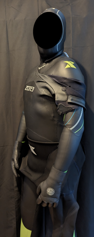 Posing in multiple wetsuits with the top two layers partially peeled