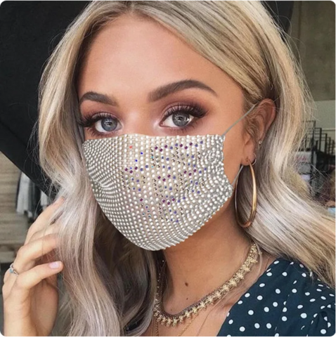 A glamorous model with long blonde hair wearing a ~diamantÃ©~ white mesh mask