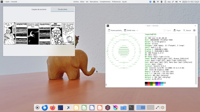 Escritorio KDE Plasma, con paneles claros, uno superior para el control de ventanas, menú global, bandeja del sistema y reloj; otro inferior (flotante) como dock.
La imagen de fondo es una fotografía de mi escritorio color nogal, tiene una pequeña maceta en forma de elefante tallado en nogal.
Hay un widget de agrupación mostrando una tira cómica de Calvin y Hobbes.
Una ventana de terminal, muestra la siguiente salida de fastfetch:

leoperbo@T450
-------------
OS: KDE neon 22.04 x86_64
Host: 20BUS09X0H (ThinkPad T450)
Kernel: 6.2.0-36-generic
Uptime: 13 mins
Packages: 2410 (dpkg), 12 (flatpak), 5 (snap)
Shell: bash 5.1.16
Display 1: 1600x900 @ 60Hz
Display 2: 1920x1080 @ 60Hz
DE: KDE Plasma 5.27.9
WM: KWin (X11)
WM Theme: Qogir-light-circle
Theme: Breeze (QogirLight) [QT], Breeze [GTK2/3/4]
Icons: Qogir-light [QT], Qogir-light [GTK2/3/4]
Font: Noto Sans (9pt) [QT], Noto Sans (9pt) [GTK2/3/4]
Cursor: Qogir (24px)
Terminal: konsole 23.8.2
CPU: Intel(R) Core(TM) i5-5300U (4) @ 2.9 GHz
GPU: Intel HD Graphics 5500
Memory: 1.50 GiB / 7.63 GiB (19%)
Disk (/): 190 GiB / 233 GiB (81%)
Battery: 98% [Not charging]
Battery 1: 99% [Not charging]
Locale: es_MX.UTF-8