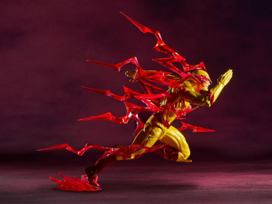 an action figure of reverse flash, he looks like flash but it yellow with red accents on his costume, the figure is in a running position, there are pieces of clear red plastic lighting bolts that are attached to the figure of reverse flash to make it look like he is really charged up