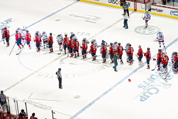 create breakthrough meeting designs: photograph from above of the end of a hockey match with the players going through a handshake line. Photo attribution: Flickr user clydeorama