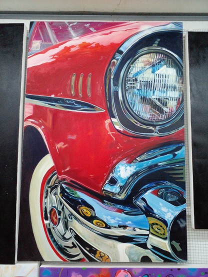 a painting of the section of the fender and bumper and headlight and the tire of a '57 Chevy, the chrome is very shiny, the paint is red and shiny and there are reflections in it