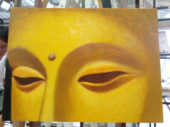 a painting of a section of the Buddha's face, from the top of his forehead to the bridge of his nose, he is gold colored, his eyes are filled with shadows, no eyes inside, there is a small sphere between his eyes