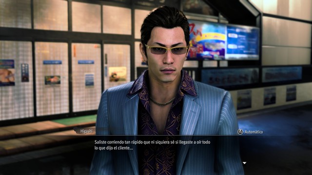 Chico joven con gafas de sol, traje blanco a rayas y camisa morada debajo también con un patrón de flores pero mas elegante