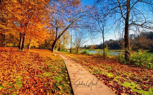 Autumn walk along the river in Northeast Tennessee in the Appalachian Mountains. Red and gold leaves adorn the walkway, with touches of green grass stilling holding on from mid-summer. A river is shown in the background, along with a brilliant blue sky.  From the Fine Art Gallery of Shelia Hunt.