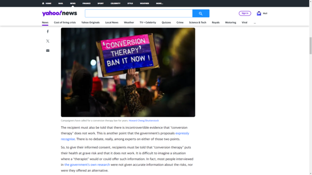 A screenshot of an article from Yahoo News featuring a photograph which I shot at a trans rights protest. The photo shows a protester holding up a placard reading, "'Conversion therapy': ban it now!"