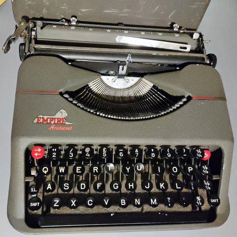 An Empire Aristocrat ultra-portable typewriter from the 1950's
It is gunmetal grey, with round black keys with white letters,