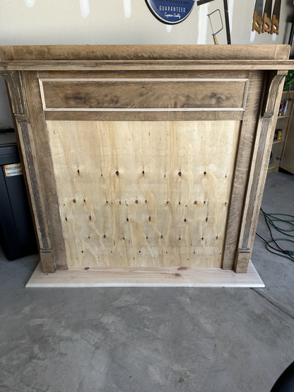 Fireplace mantle standing up with a wooden insert where the fireplace goes. Ready to be painted.