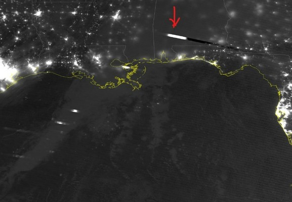 NOAA-20 AVHRR visible nighttime image of storms across the southern US with lightning visible in the image (white dashes above gray clouds)