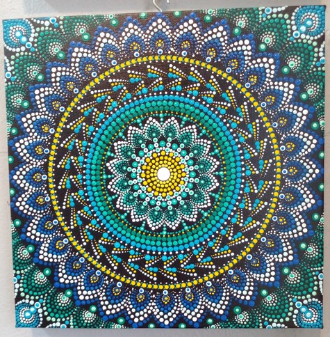 a blue, green, yellow, and white mandala on black background