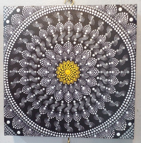 a silver mandala on black background, a golden wheel in the center