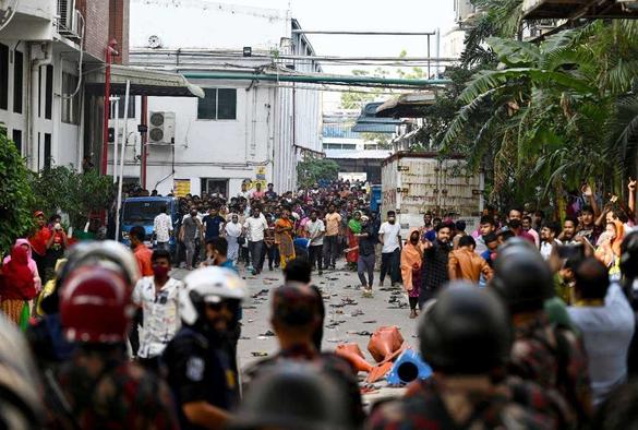 A crowd of people faces off against the police force