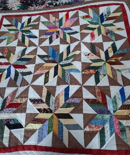 a quilt with nine eight-pointed stars on it, multi-colored