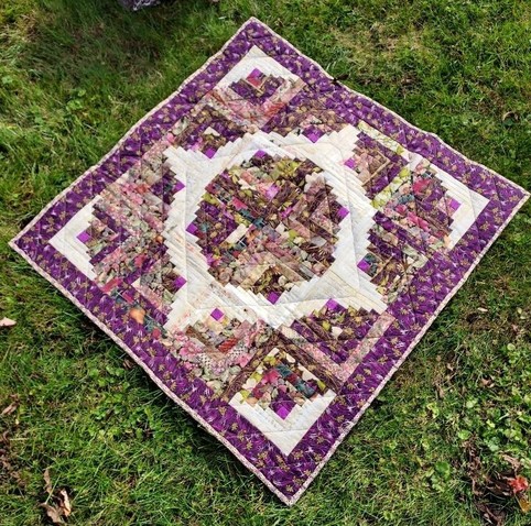 a photo of a floral quilt, in white, purples, and greens