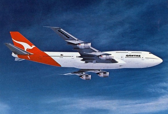 Big 4 engine jetliner flying above with blue skies and wispy white clouds