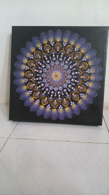 a short video clip of a purple, white, and yellow mandala on black background