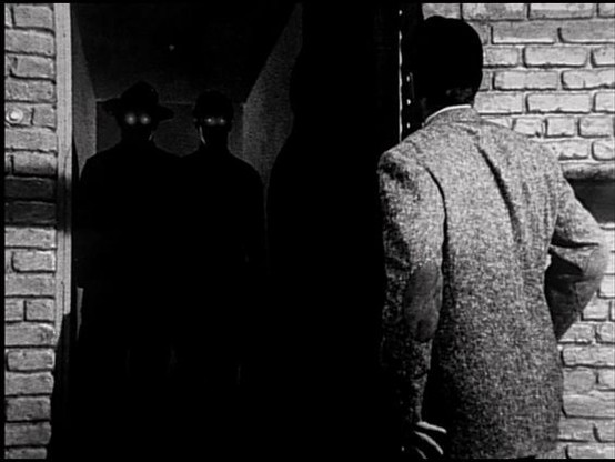a man looking into a doorway where two fedora hatted men stand in shadow. their eyes are glowing