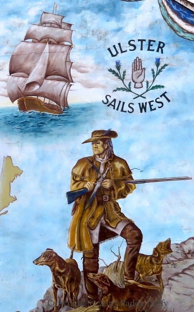 Part of a mural, showing a sailing ship and an American frontiersman with rifle and three dogs. In the top right a red hand is flanked by thistles and above and below by "Ulster" and "Sails West"