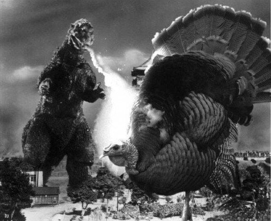 A scene Godyilla vs Tom Turkey, as they rampage through a city causing mayhem and destruction.
