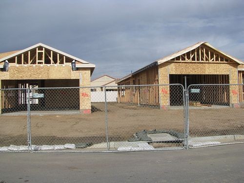 the right conference: Photograph of the framed structures of spec homes on a building lot surrounded by chain-link fence. Image attribution: http://www.flickr.com/photos/thetruthabout/ / CC BY-SA 2.0