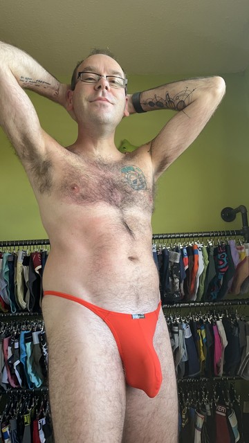Hairy gay guy wearing an orange ArjunKroos thong