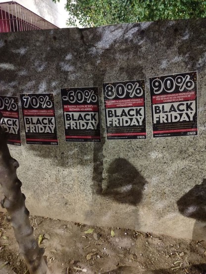 Foto donde se ven 5 carteles en un muro con los porcentajes mencionados en el post con los mismos colores del Black Friday que usan las marcas.