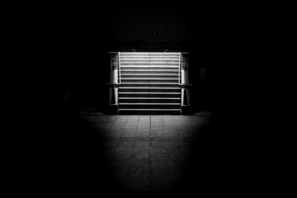 You can see a photo in Black and White of a public underground stairs with a lot of shadows around them.