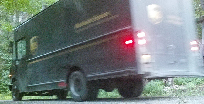 A photograph of a UPS truck going down my driveway, driven by the UPS guy