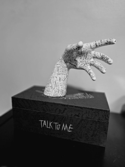 A sculpture of a grasping hand with many small inscriptions.
