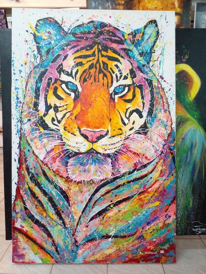 a painting of the head and shoulders of a tiger done in bright colors, lots of drip and splatter effects on it