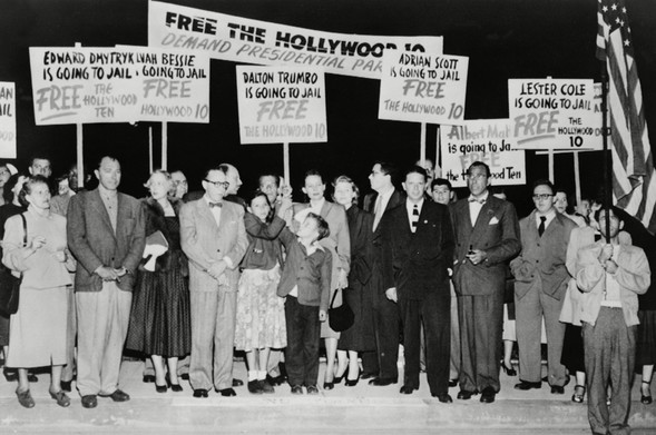 Protestors carrying picket signs in support of Dalton Trumbo and the Hollywood 10, and opposing the anti-communist witch hunt.