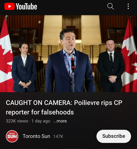 A screenshot from youtube with the same title aa before. Poillievre is standing at a microphone. He is wearing a tight fitting blue suit with a button up blue shirt and light blue tie. Behind him to his right is a woman in a dark suit with her hands clasp in front of her. She is standing just to the inside of a Canadian flag which frames the video shot. To Poillievre's left is a man in a dark suit and tie with hands clasp in front of him and standing just to the side of another Canadian flag framing the right side of the video frame. The video was posted by the Toronto Sun 1 day ago and was viewed 323K times as of the time of the screenshot.